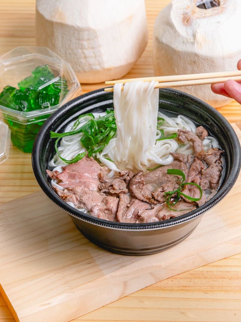 Beef pho — chopsticks lifting the noodles